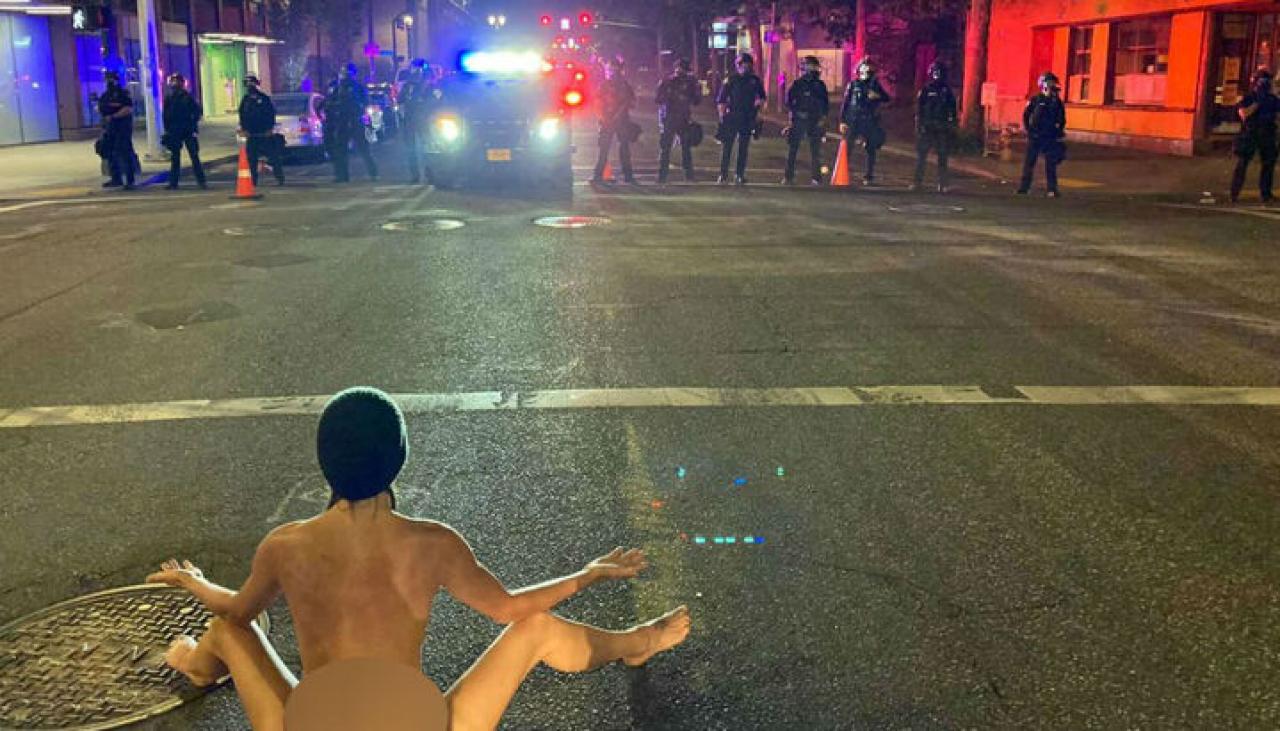 Naked woman faces off against police during US protest | Newshub